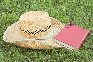 Image showing Straw hat with a book