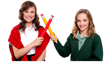 Image showing Smiling teenagers making cross sign with pencil