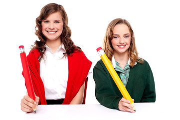 Image showing Female students writing with big pencil