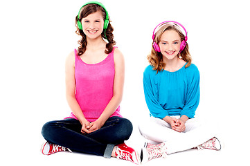 Image showing Teenage friends sitting on floor listening music