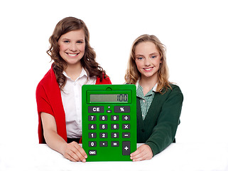 Image showing Girls showing big green calculator to camera