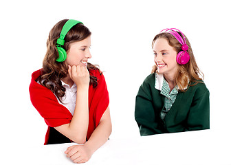 Image showing Pretty girls enjoying music. Looking at each other