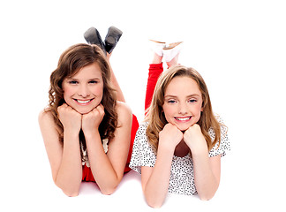 Image showing Girls posing with hands on chin. Lying on floor