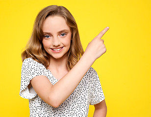 Image showing Smiling caucasian girl indicating upwards