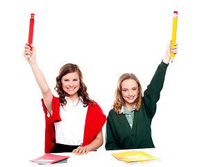 Image showing Students showing big pencil in raised arm