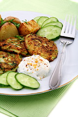 Image showing Zucchini fritters,garnish and sour cream sauce. 