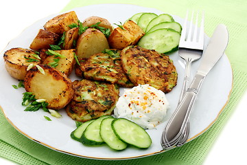 Image showing Fritters zucchini, potatoes and sour cream sauce.