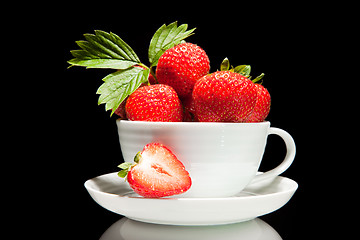 Image showing red strawberry in white cup on a black background