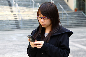 Image showing Asian woman texting message by phone