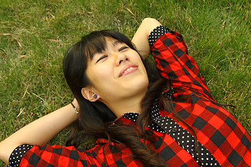 Image showing Asian woman sleeping on the grass and very relax