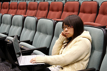 Image showing Asian student studying in lecture hall with laptop
