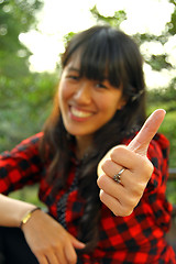 Image showing Asian woman thumbs up outdoor