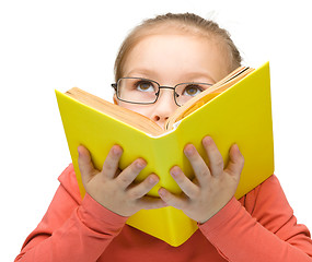 Image showing Little girl is dreaming while reading book