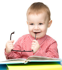 Image showing Cute little child play with book