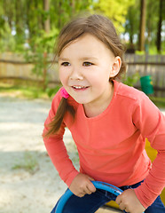 Image showing Happy little girl is swinging on see-saw