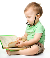 Image showing Cute little boy reads a book