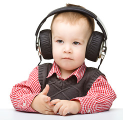 Image showing Cute little boy enjoying music using headphones