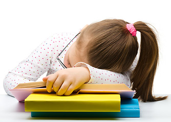 Image showing Cute little girl is sleeping on a book