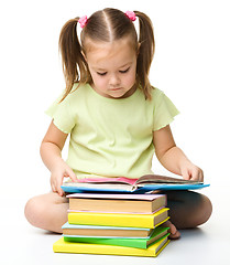 Image showing Cute little girl reads a book