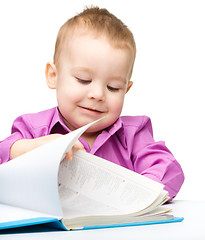 Image showing Cute little child play with book