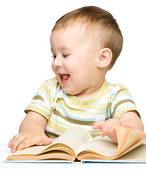 Image showing Cute little child play with book