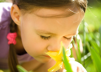 Image showing Portrait of a cute little girl smelling flowers