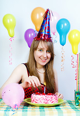 Image showing Birthday. Happy attractive girl lights a candle