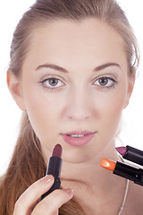 Image showing young beautiful woman applying colored lipstick 