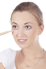 Image showing young beautiful woman applying concealer on face