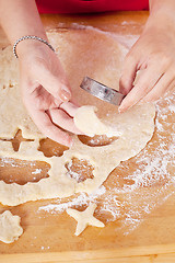 Image showing beautiful woman is baking cookies for christmas