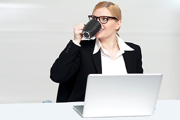 Image showing Businesswoman enjoying coffee at work desk