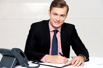 Image showing Handsome young man making notes