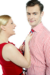 Image showing Glamorous woman pulling man by his tie
