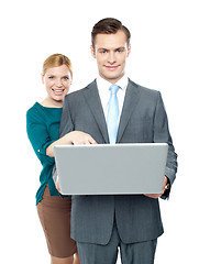 Image showing Woman pointing into laptop while guy holding it