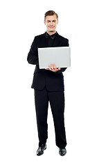 Image showing Smiling young man working on laptop