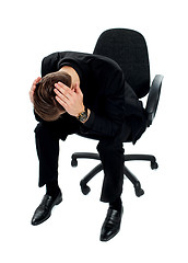 Image showing Frustrated young man sitting on chair