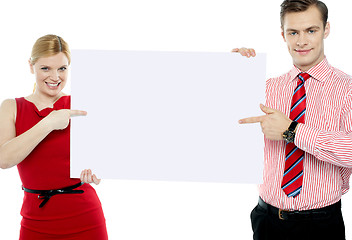 Image showing Business colleagues pointing at blank signboard