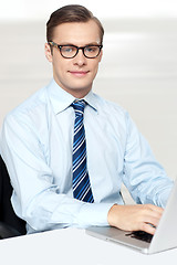 Image showing Man sitting on chair using laptop in office