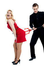 Image showing Evil guy poking sensual woman in red