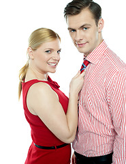 Image showing Girl in red holding businessman by his tie