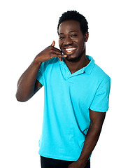 Image showing Smiling young man showing calling gesture