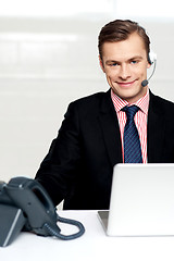 Image showing Male executive wearing headsets and smiling