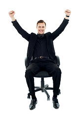 Image showing Excited young man sitting on chair