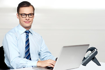 Image showing Handsome corporate male tying on laptop