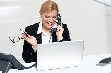 Image showing Woman talking on phone holding eye glasses