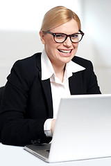 Image showing Smiling young female executive at work desk