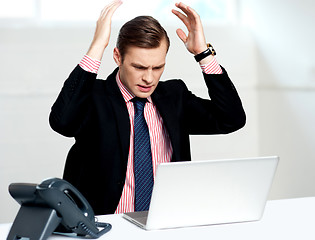 Image showing Disappointed businessman looking at laptop