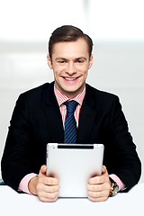 Image showing Cheerful male executive holding digital device