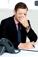 Image showing Young man having severe cold. Sneezing