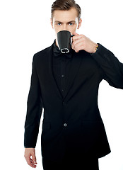 Image showing Smart young man drinking coffee in black cup